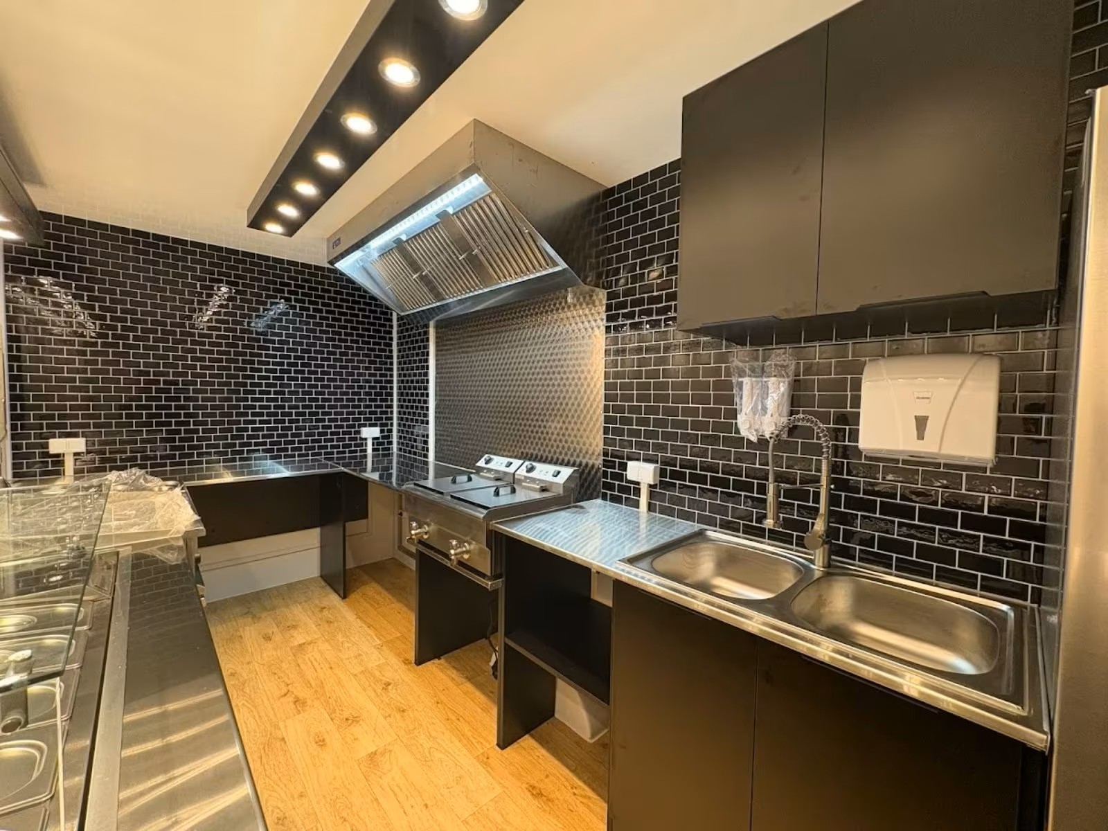 Foodtruck Innenraum mit Edelstahl Arbeitsflächen und schwarzer Möblierung